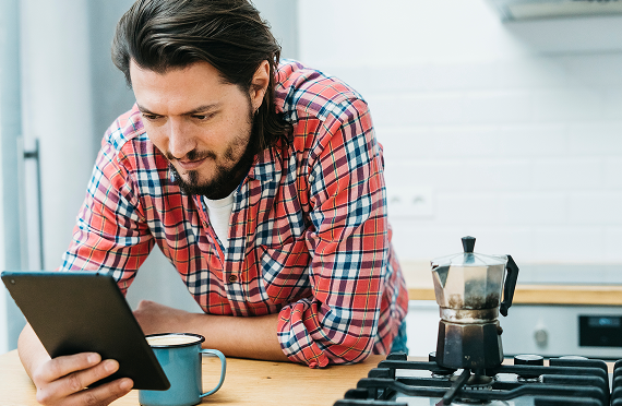 man leaning kitchen counter looking smart phone 1